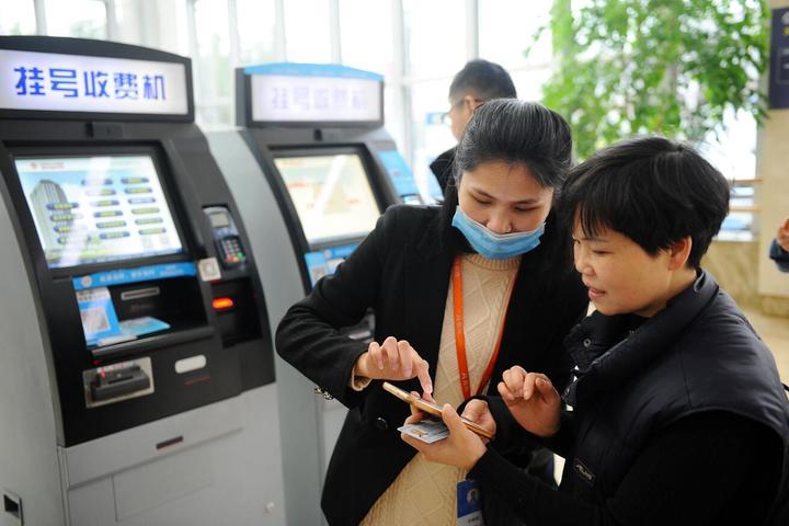 1月3日,东阳市人民医院的工作人员在指导市民通过手机平台挂号.