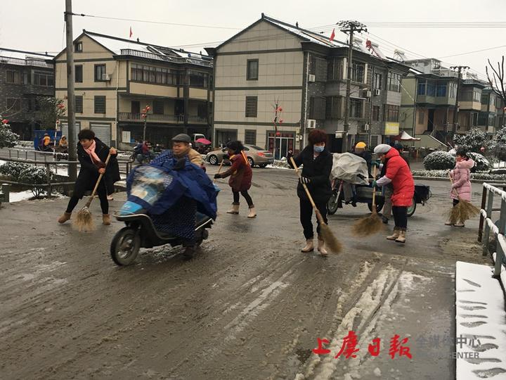 东关街道中心幼儿园老师们在幼儿园门口及通往幼儿园的桥上清除积雪.