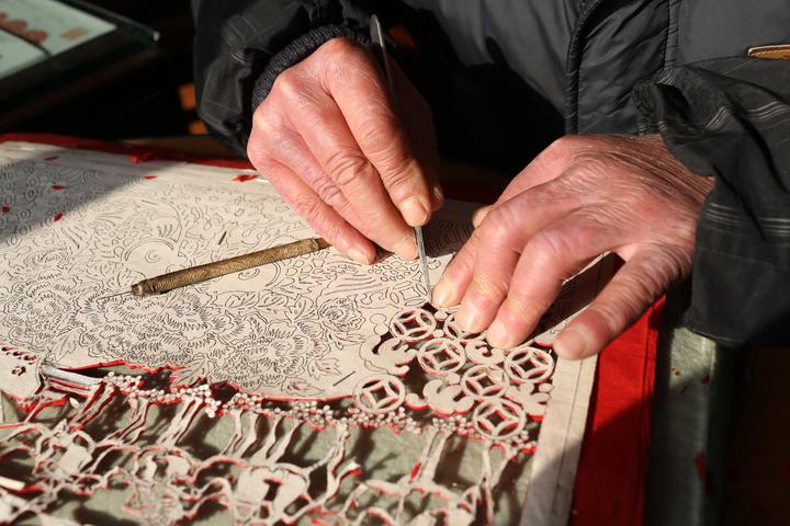 这个退休老人用剪纸刀将一张张红纸,变成一幅图画,一个故事,一个传说