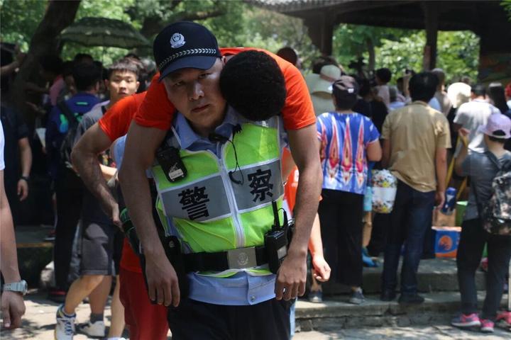 一位选手突然晕倒,民警将其背到急救点送医.