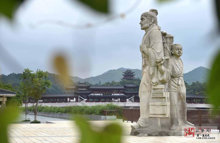 徐霞客雕像与远处的桥阁构成一道文化旅游景观.