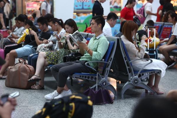 茫茫人群中,一位男青年在看书.记者 倪雁强 摄