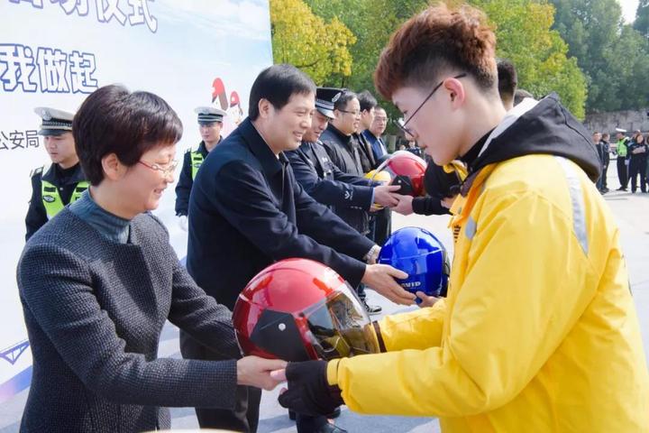 参会领导共同为现场的电动车驾驶人代表送上安全头盔诸暨市委常委