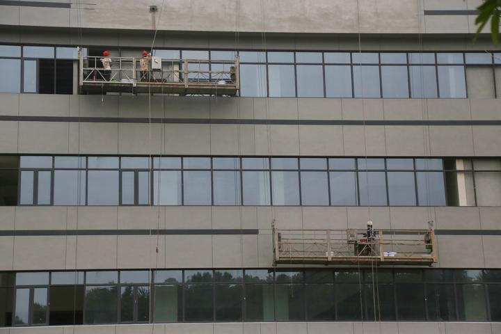 施工人员正在进行外墙安装玻璃窗及外墙装饰