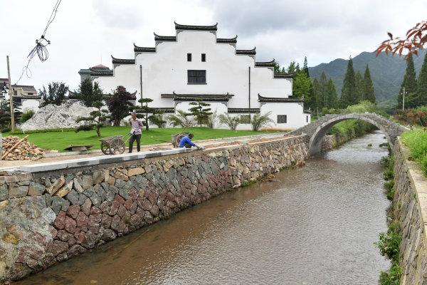 7月18日,施工人员在东阳市虎鹿镇厦程里村建设村口景观.