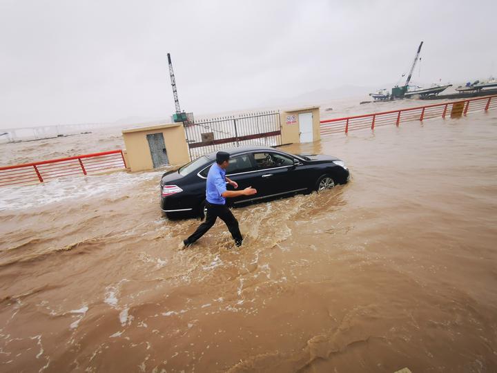 台风致普陀东港海滨沿线海水倒灌民警引导车辆转移