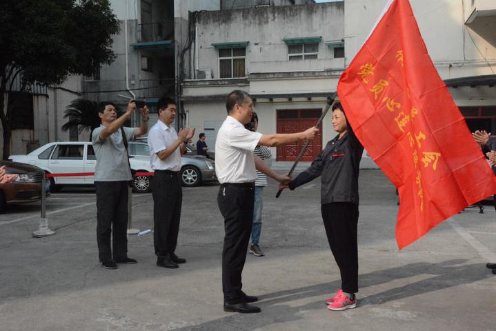 技协办副主任宋欣梅从总工会常务副主席徐雄强的手里接过"出征旗帜"