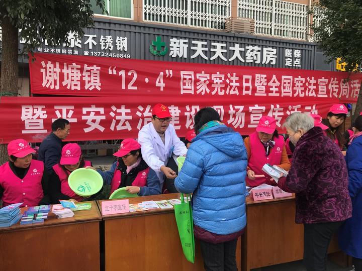 医院工作人员和镇政府工作人员一同为过往社区群众进行国家宪法日宣传
