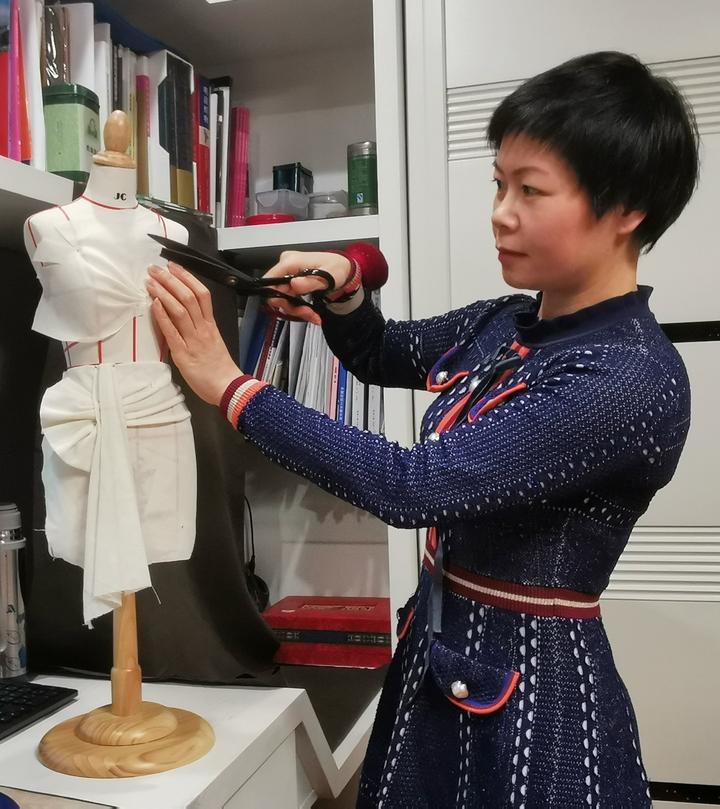 杭职院服装专业教师章瓯雁在家用小人台进行礼服的立体剪裁设计创作.