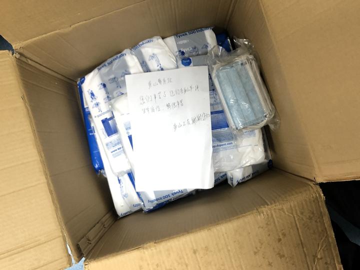 工友将一箱口罩放置鱼山警务站后