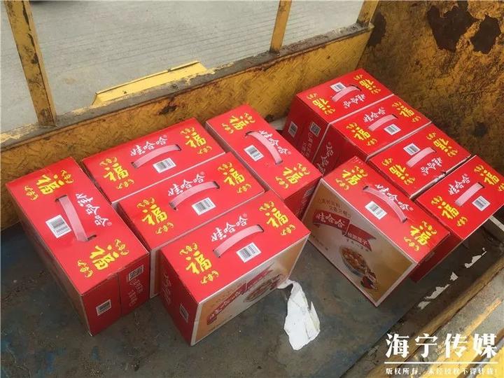 匆匆把车停在门口后 从车里拎出一箱又一箱的八宝粥 堆在了村委会大厅