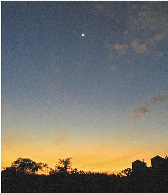 一轮弯弯的月亮和一颗星星依然明亮,仿佛在迎接冉冉升起的朝阳.