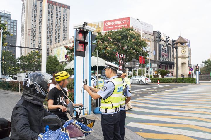 交警在市民大道和江杨路红绿灯处,处理电瓶车带人违章.jpg