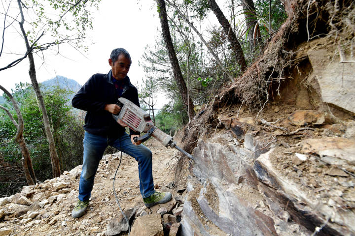67岁的蔡彭民正在用电锤打石头,辛劳可想而知.
