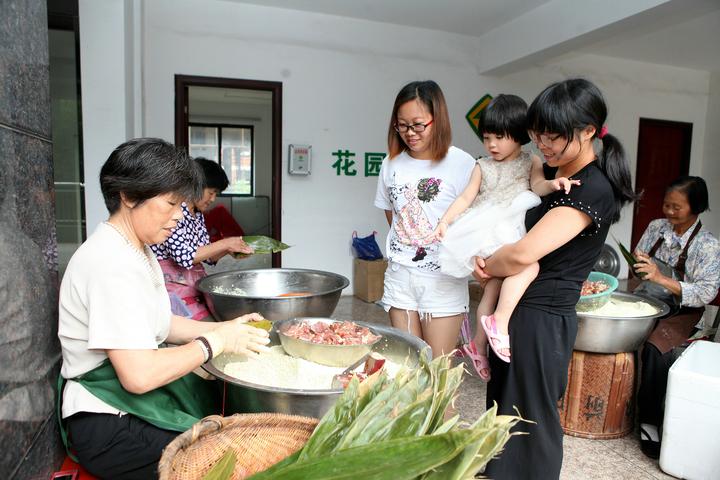 6月8日,東陽市南馬鎮花園村陽光城小區內,幾位阿姨在忙著包鮮肉粽.