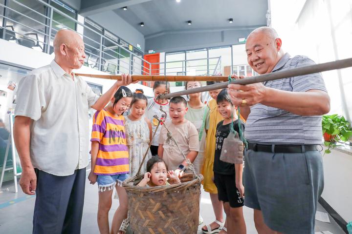 孩子们正在体验悬秤称人.