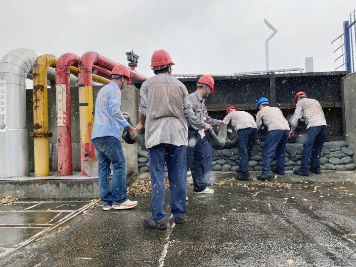 浙能温州燃机公司的党员们冒雨为码头闸板加固。 陈筱松 摄.jpg